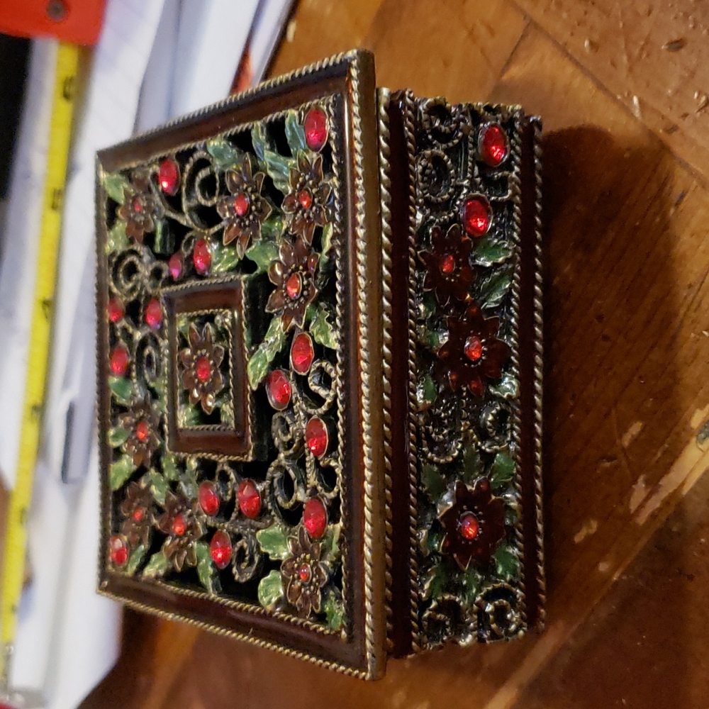 Brass trinket box. Has pretty red jewels and velvet lining on the inside bottom.